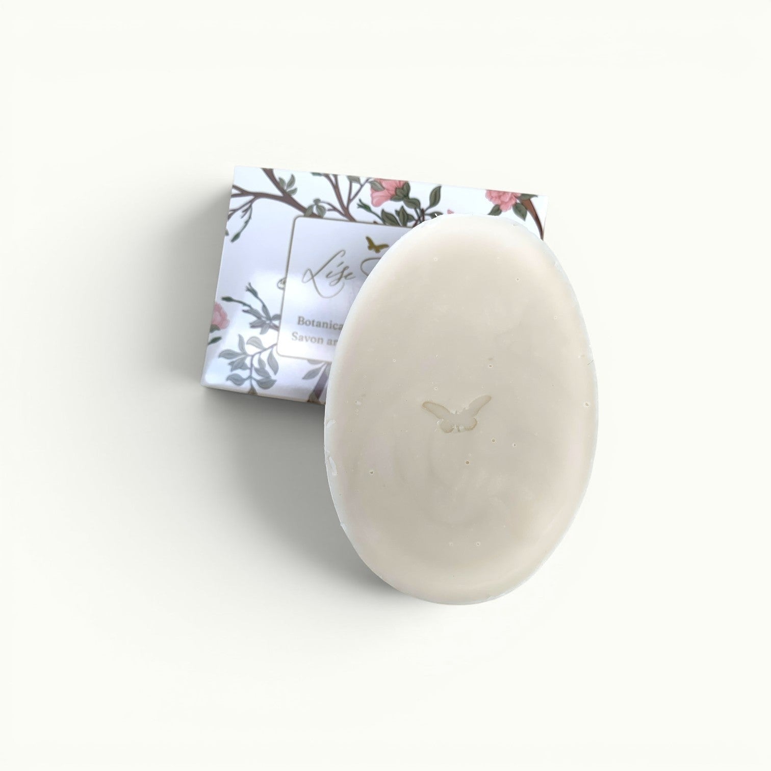 Lise Fiola Creations artisanal soap bar with a delicate cameo butterfly design and botanical floral packaging.