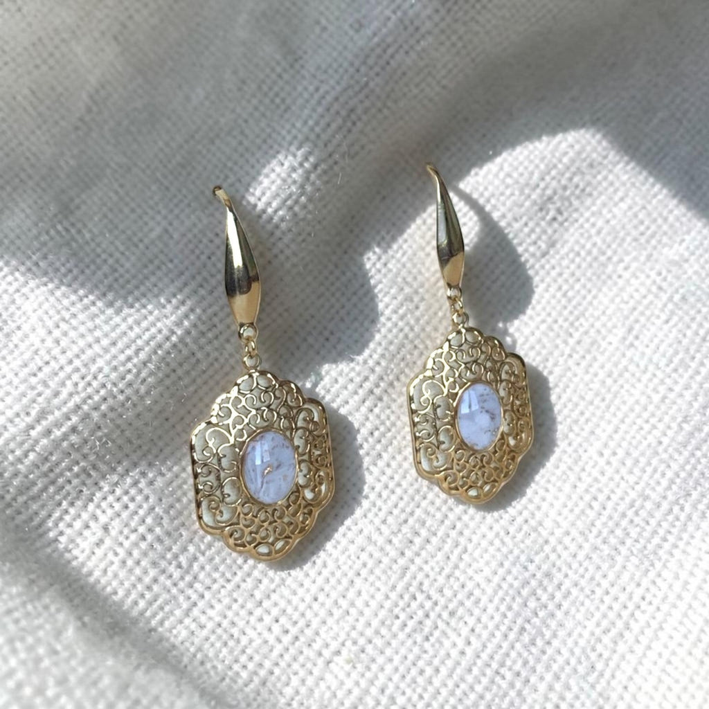 Lise Fiola Creations vintage-inspired gold filigree earrings with marbled cabochon centers on a white fabric background