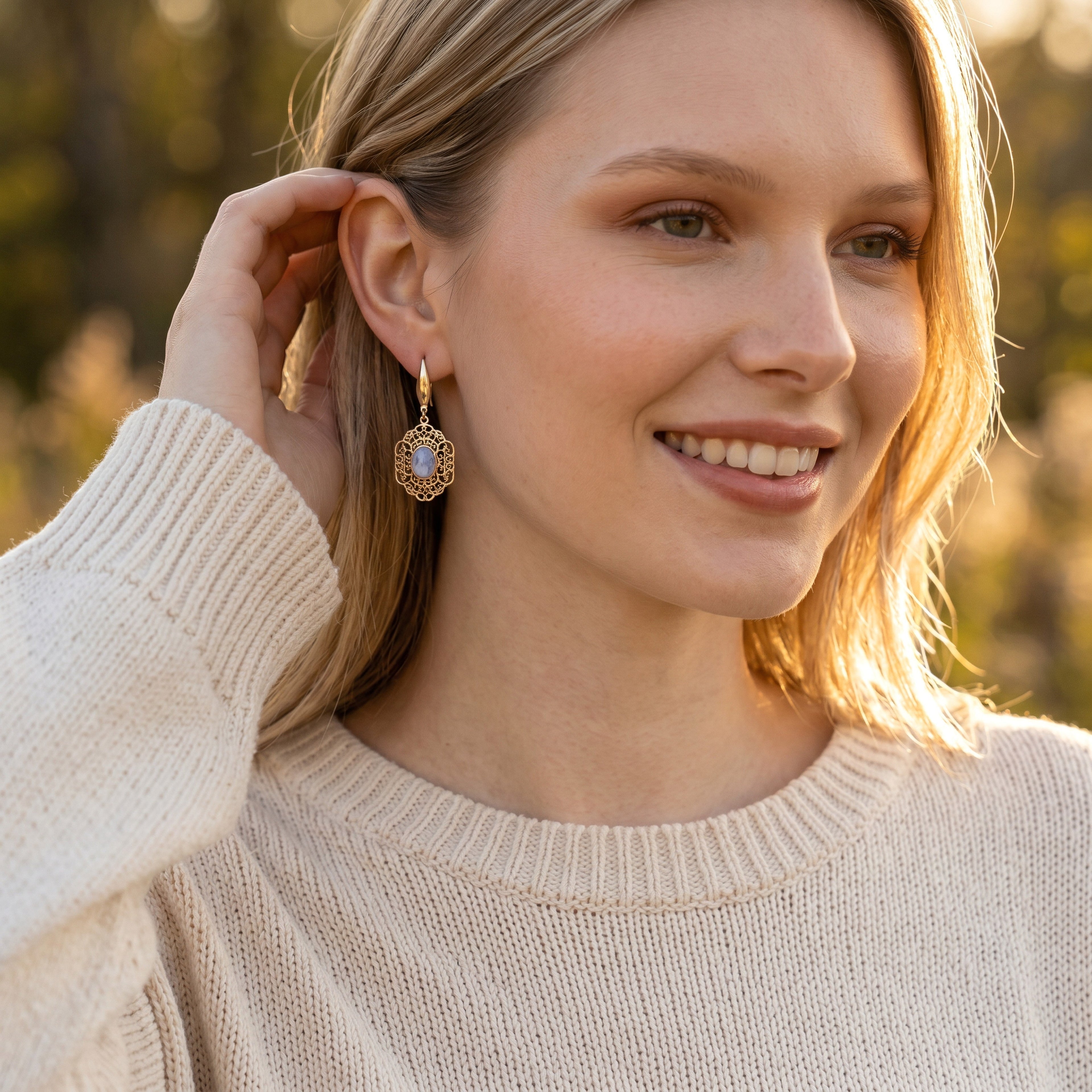 Lise Fiola Creations vintage-inspired gold filigree earrings with marbled cabochon worn by a woman in soft sunlight.