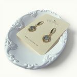 Lise Fiola Creations Golden Eye earrings featuring marbled grey polymer clay set in 18k gold-plated brass frames.