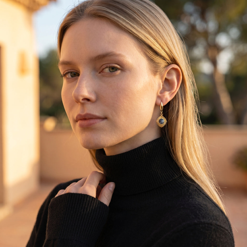 Lise Fiola Creations Golden Eye earrings with marbled dark clay and gold-plated brass worn by a blonde woman