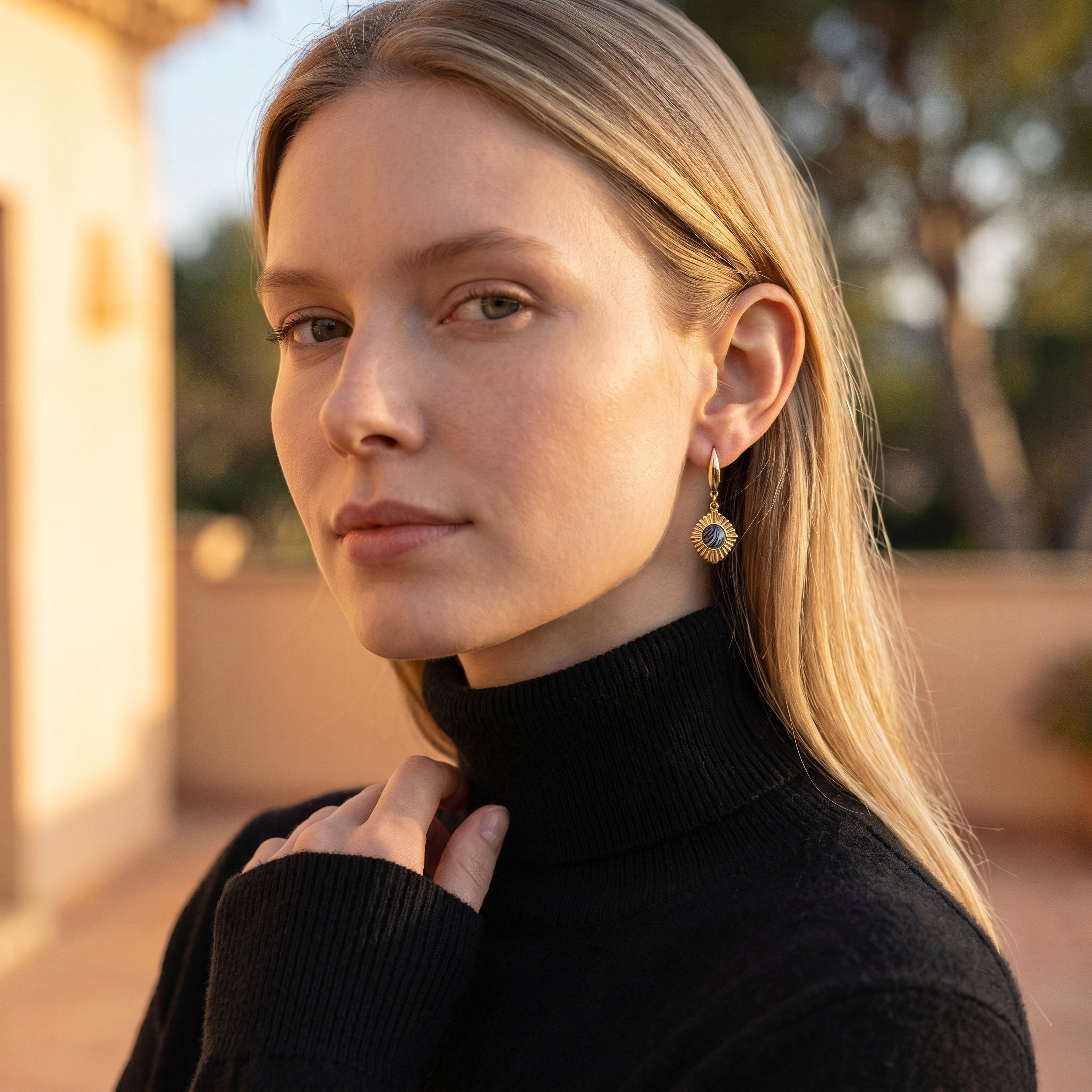 Lise Fiola Creations Golden Eye earrings with marbled dark clay and gold-plated brass worn by a blonde woman