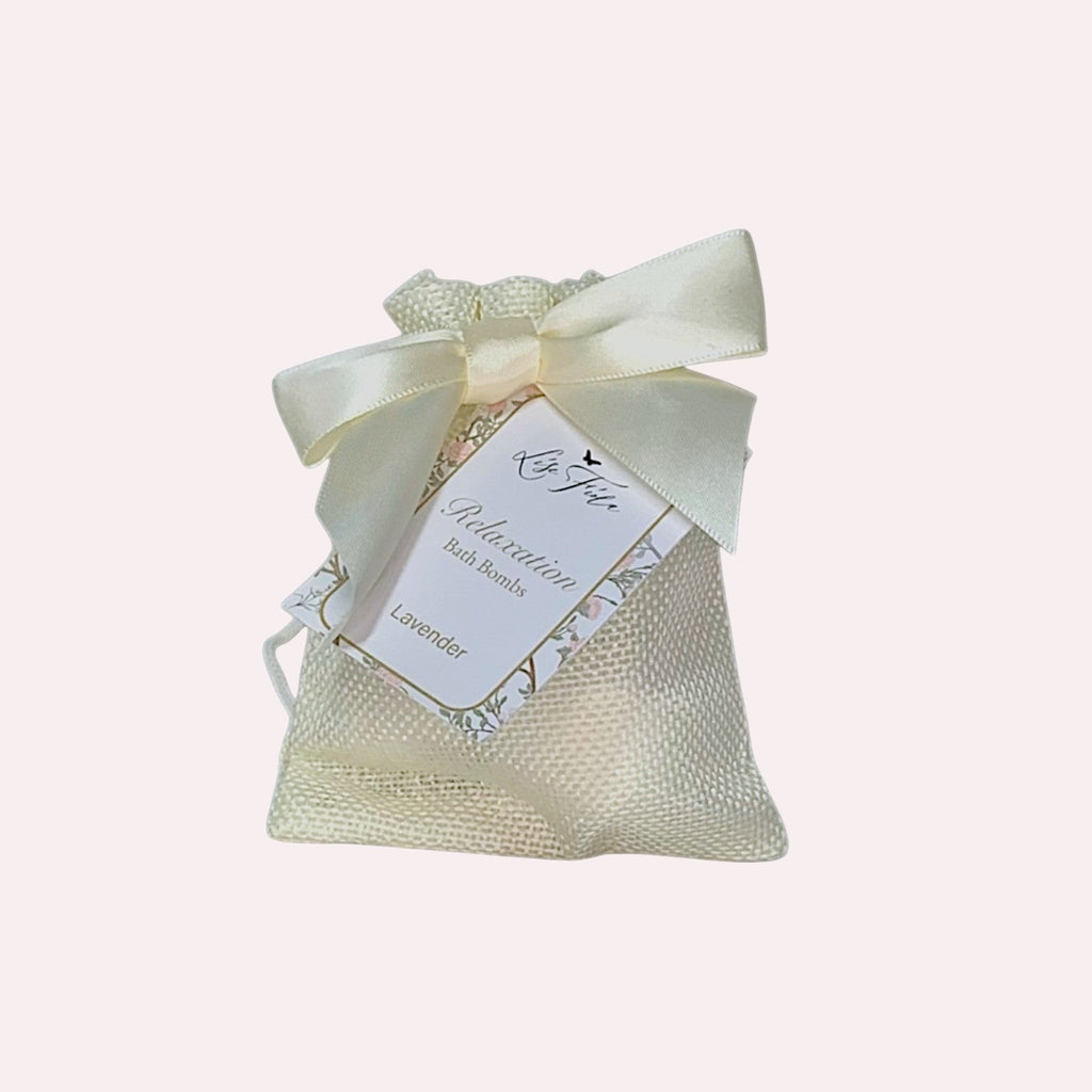 Lise Fiola Creations mini lavender bath bombs in a cream burlap drawstring gift bag with a satin ribbon bow.