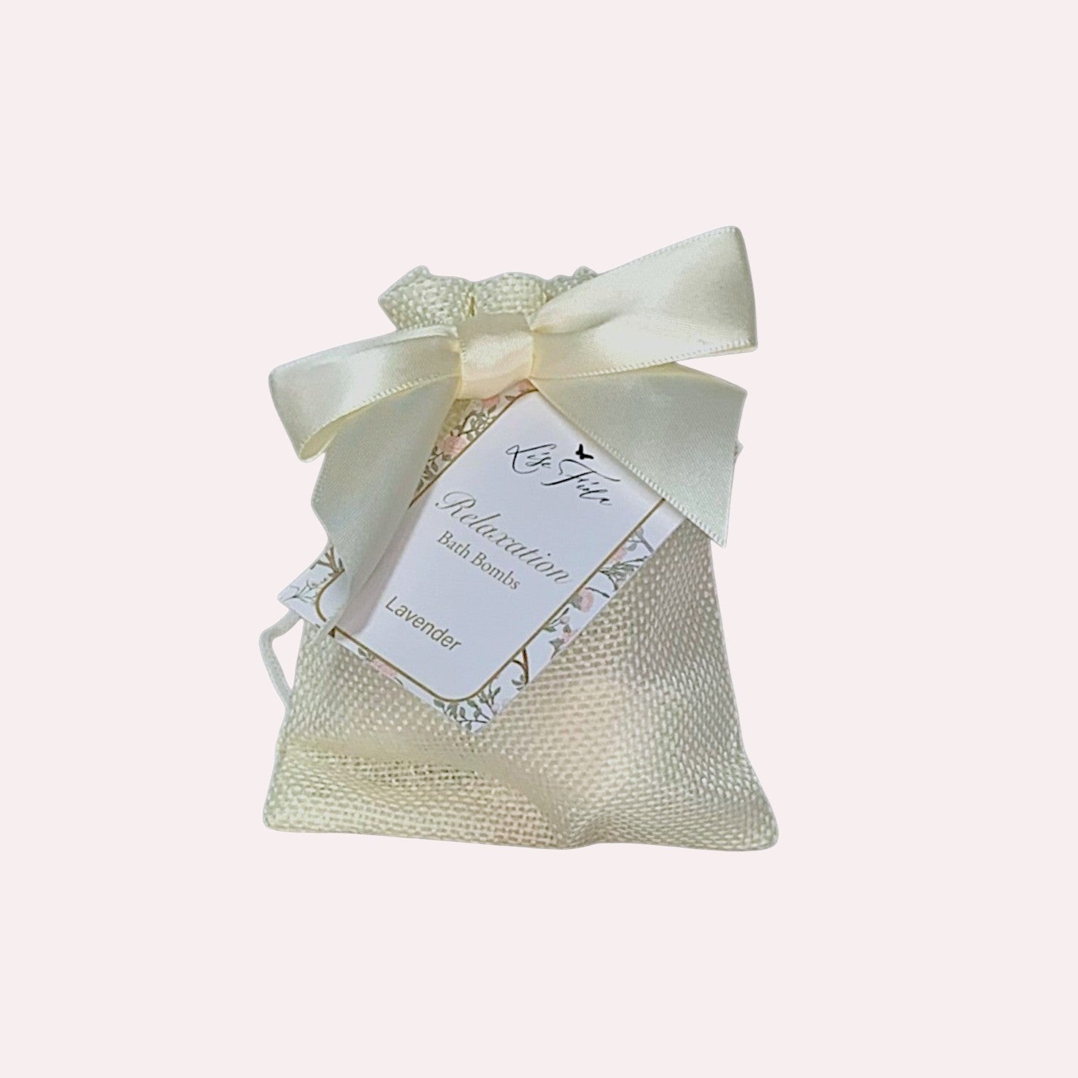 Lise Fiola Creations mini lavender bath bombs in a cream burlap drawstring gift bag with a satin ribbon bow.
