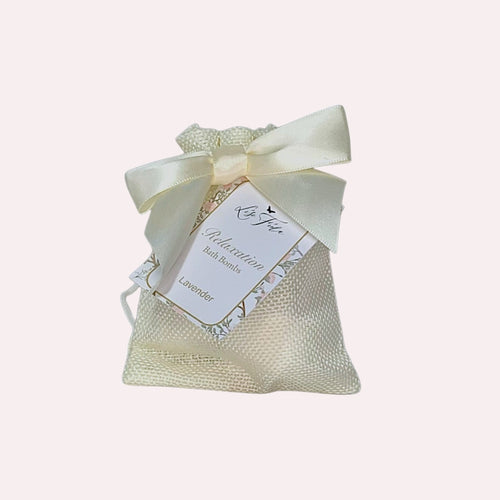 Lise Fiola Creations mini lavender bath bombs in a cream burlap drawstring gift bag with a satin ribbon bow.