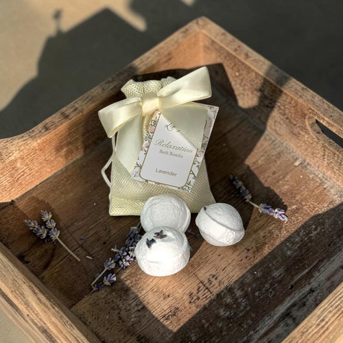 Lise Fiola Creations mini lavender bath bombs with dried flowers in a cream gift bag with a satin ribbon bow.