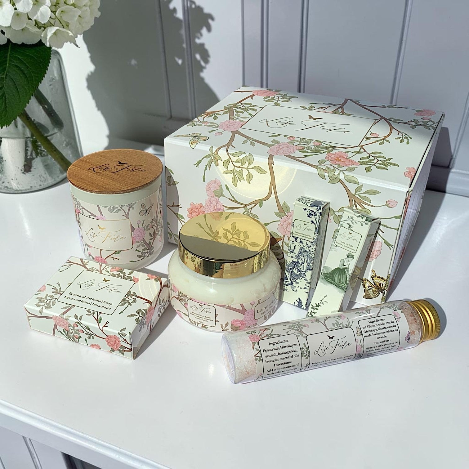 Lise Fiola Creations luxurious self-care gift set in a floral magnetic box with body butter, soap, candle, and salts.