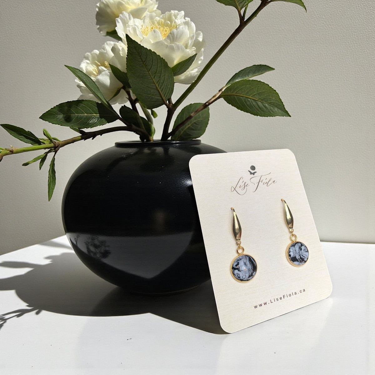 Lise Fiola Creations handmade polymer clay earrings with black, grey, and white marble patterns and gold accents.