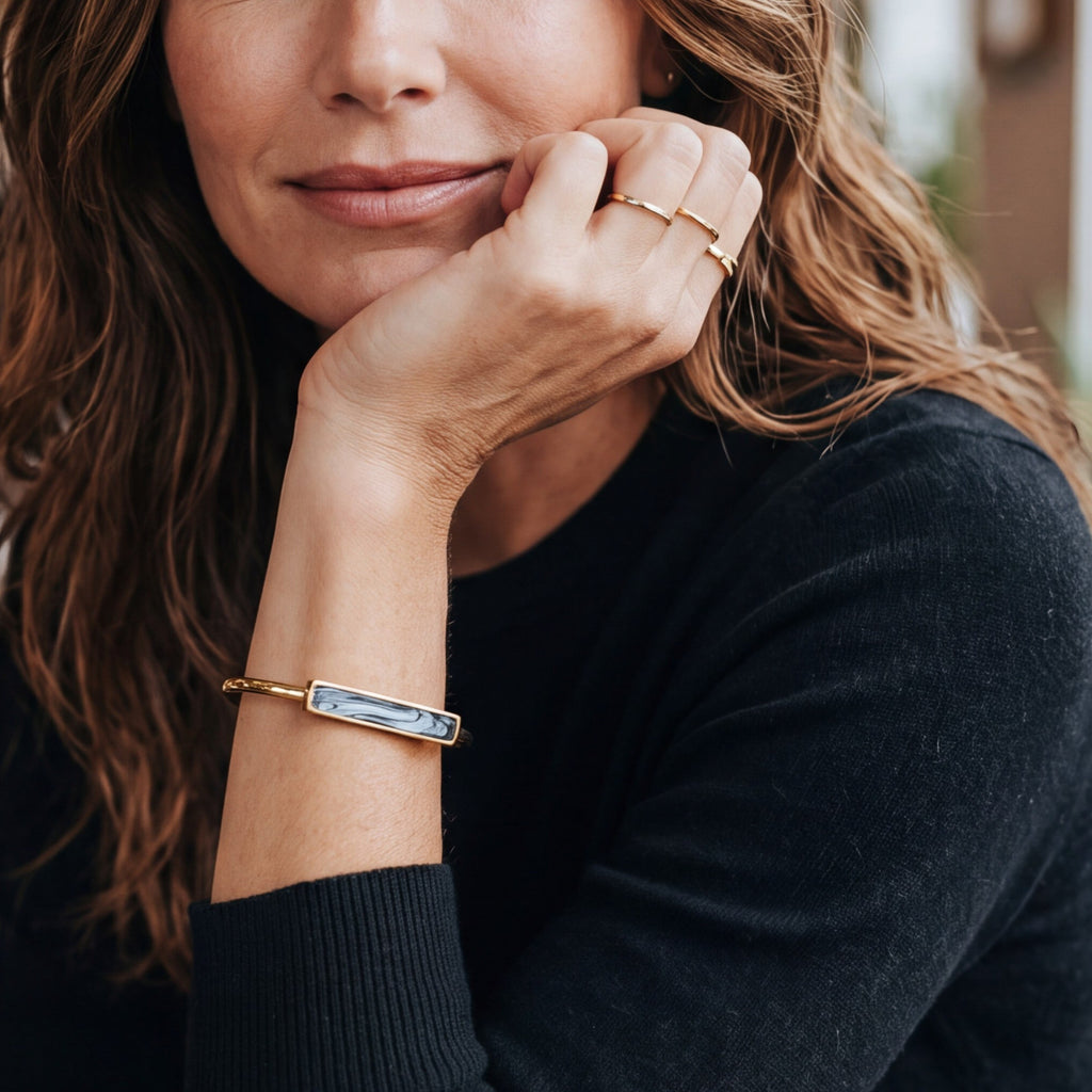 Lise Fiola Creations handmade bangle bracelet with marbled polymer clay and 18k gold plated brass on a woman's wrist.