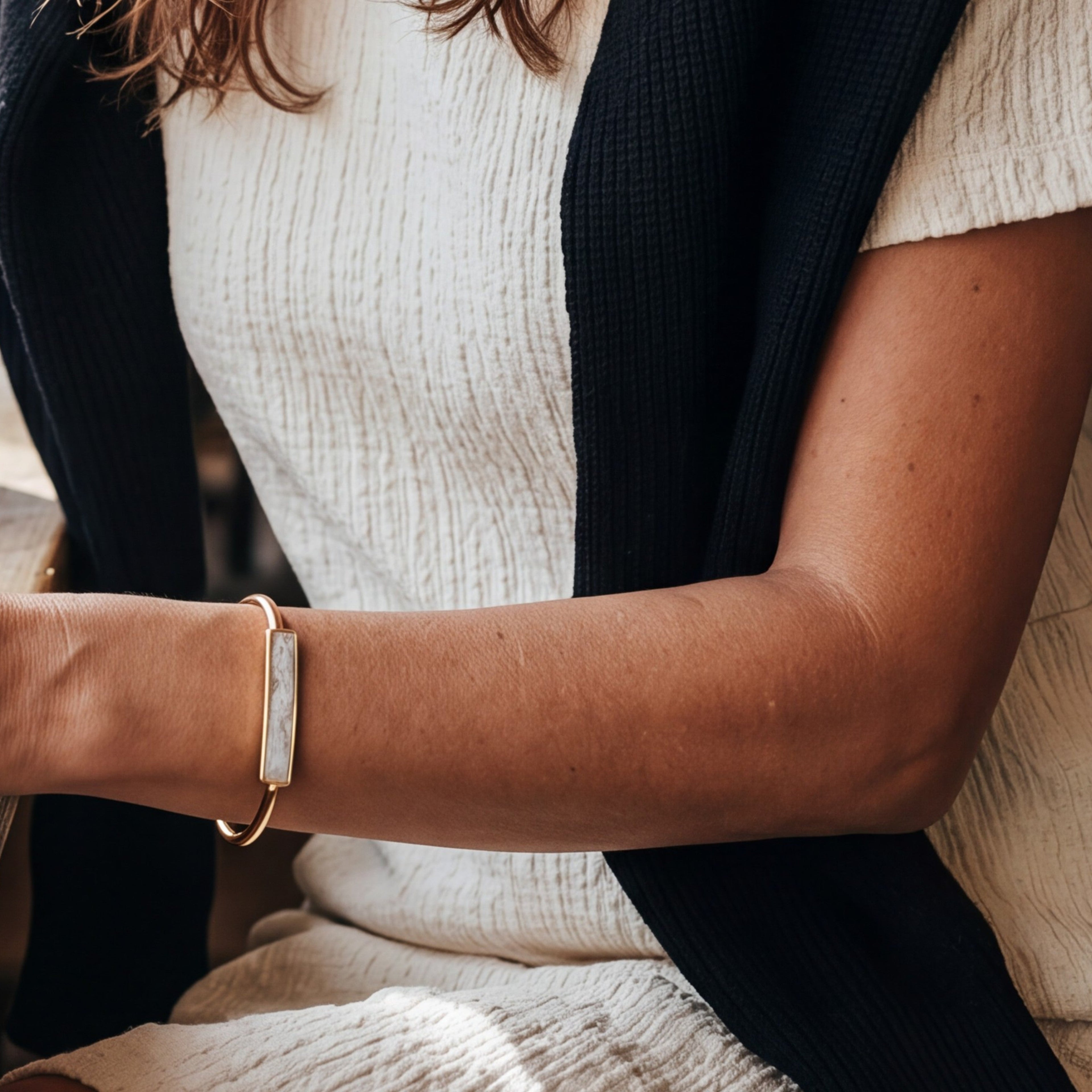 Lise Fiola Creations adjustable gold plated bangle bracelet with a marbled polymer clay bar on a woman's wrist.