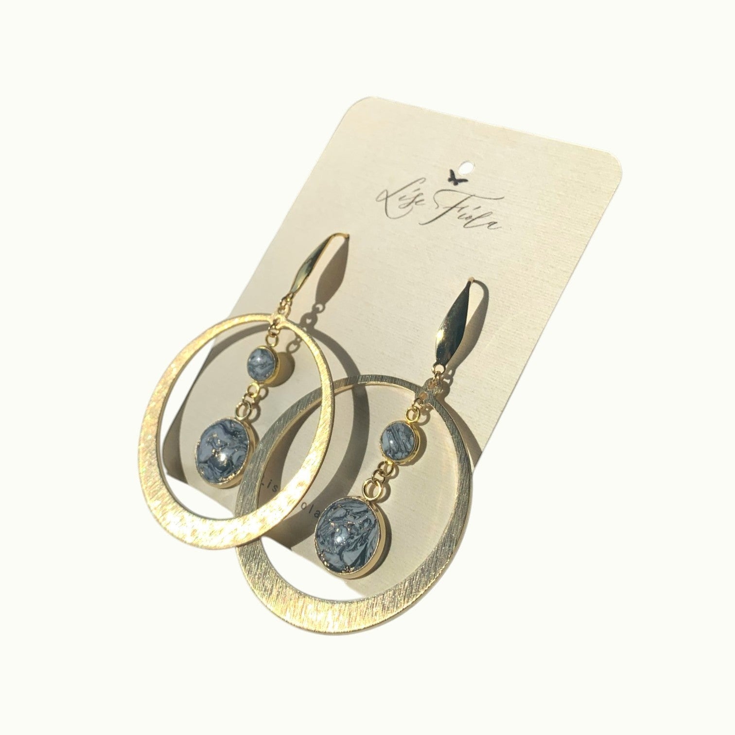 Lise Fiola Creations handmade statement earrings featuring gold-plated brass hoops and marbled black and grey clay.