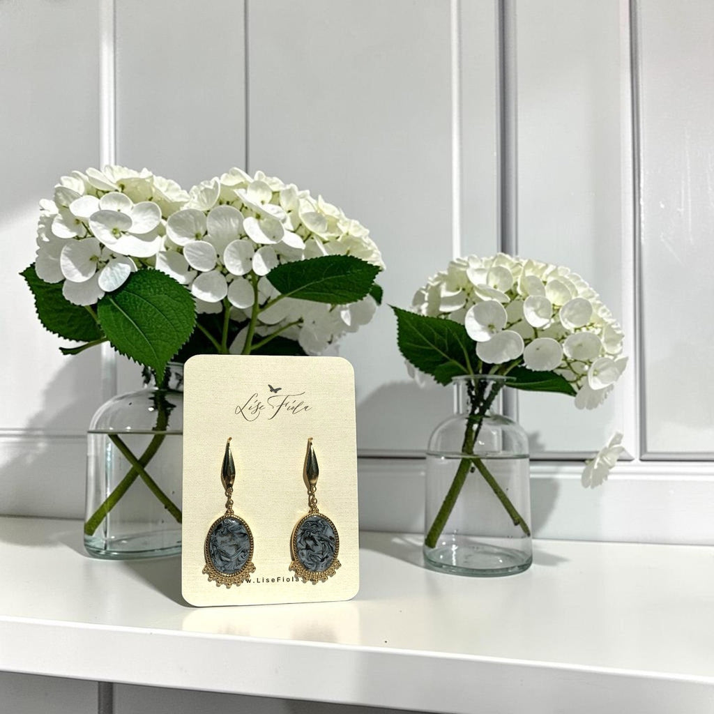Lise Fiola Creations handmade oval drop earrings with marbled grey and gold clay, displayed on a branded card.
