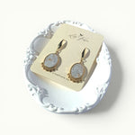 Lise Fiola Creations oval drop earrings with marbled grey, white, and gold polymer clay and 18k gold-plated brass.