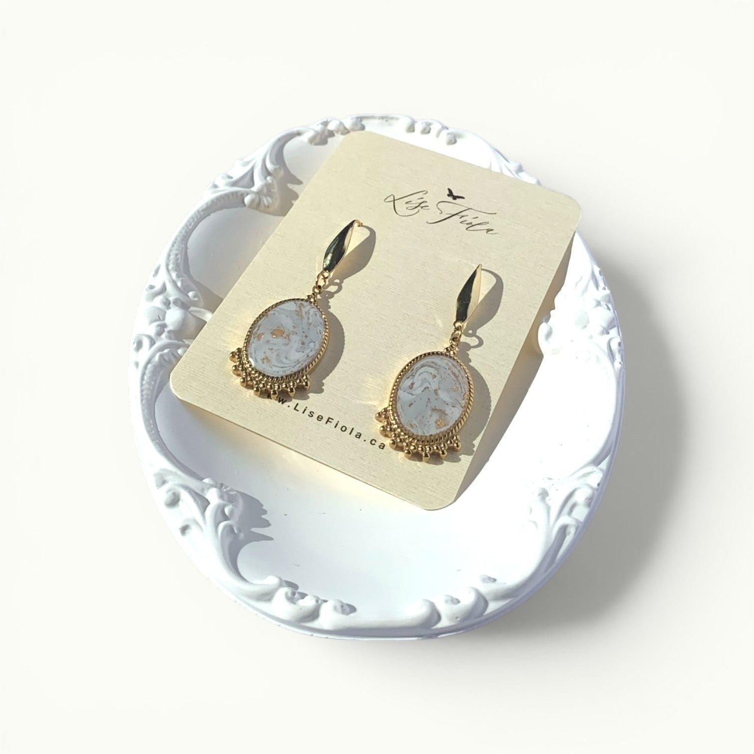 Lise Fiola Creations oval drop earrings with marbled grey, white, and gold polymer clay and 18k gold-plated brass.