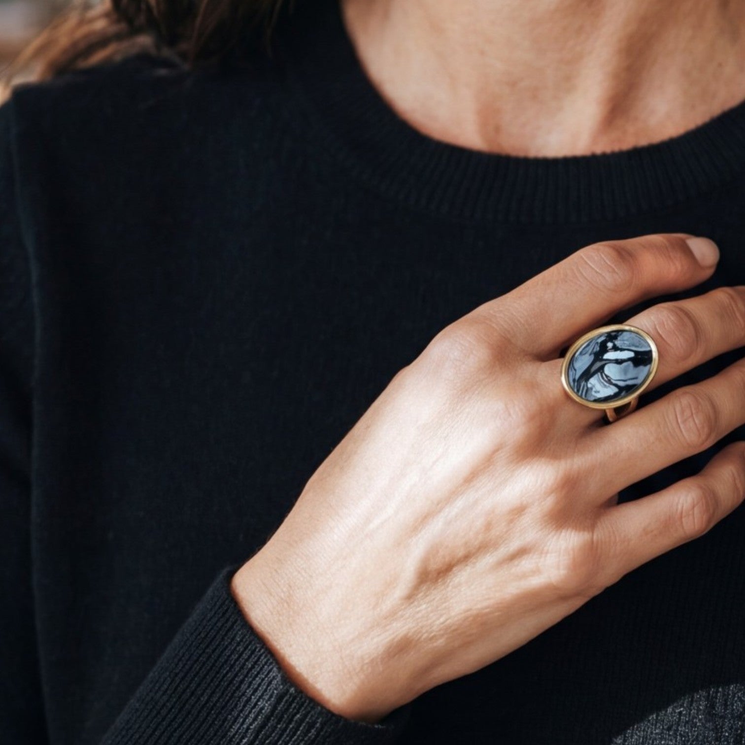 Lise Fiola Creations oval polymer clay ring with black, grey, and white marble pattern on an adjustable gold band.