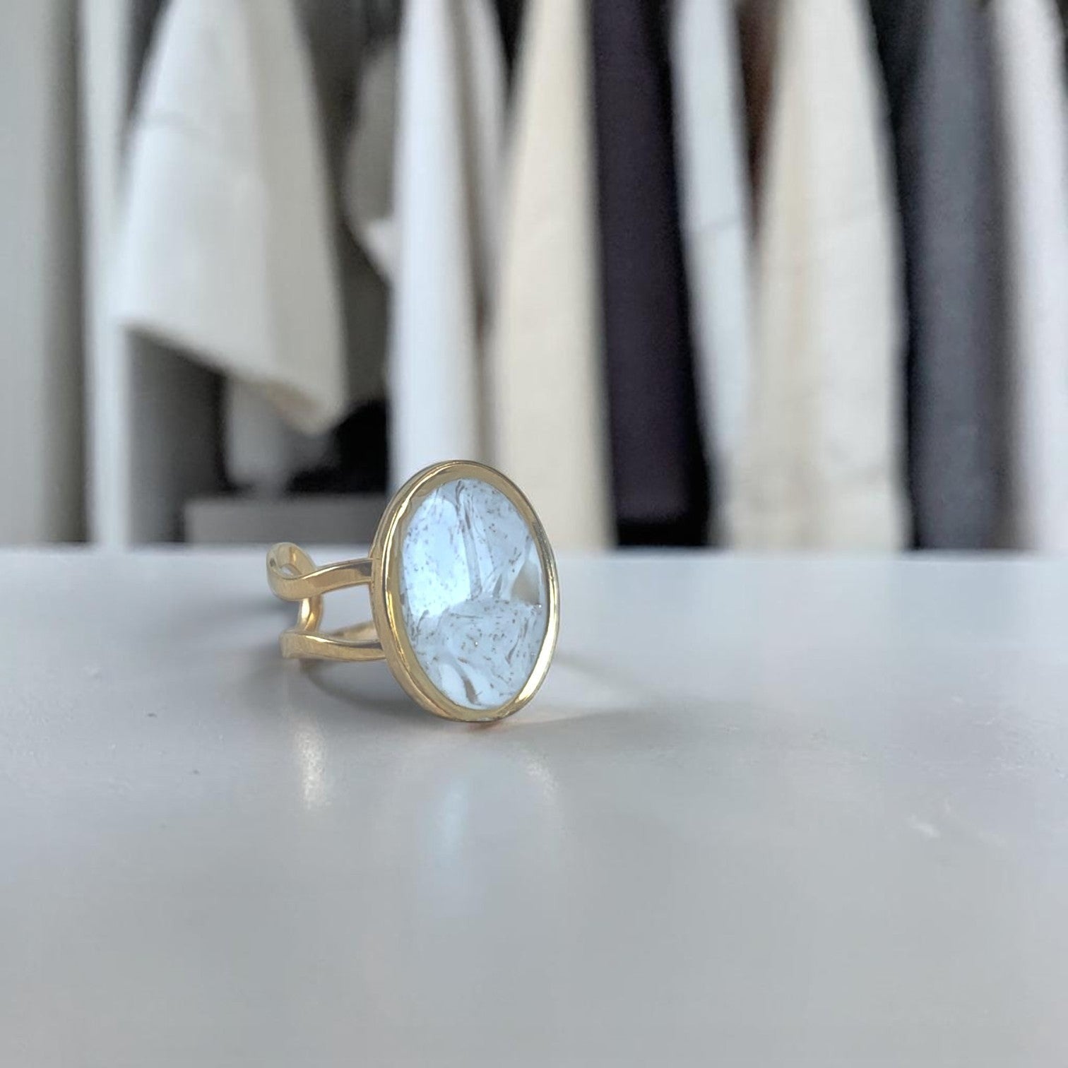 Lise Fiola Creations handmade oval ring with marbled beige, grey, and gold polymer clay on an adjustable gold band.