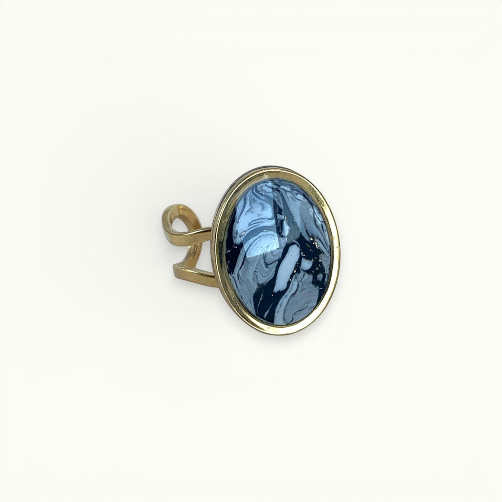 Lise Fiola Creations oval ring with black, grey, and white marbled polymer clay and an adjustable gold plated band.