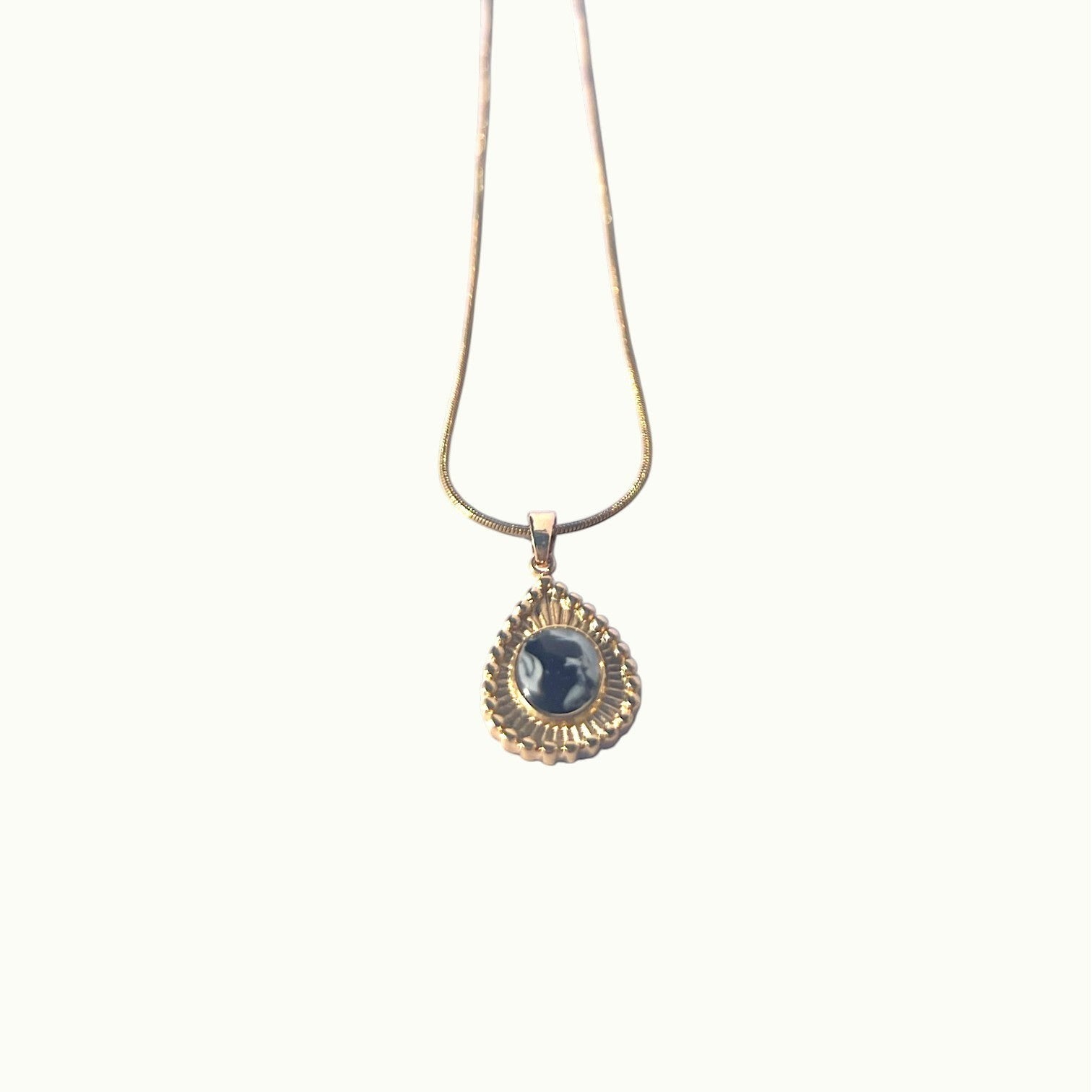 Lise Fiola Creations Sun Ray Drop necklace with a dark marbled polymer clay pendant in a 14K gold-plated bezel.
