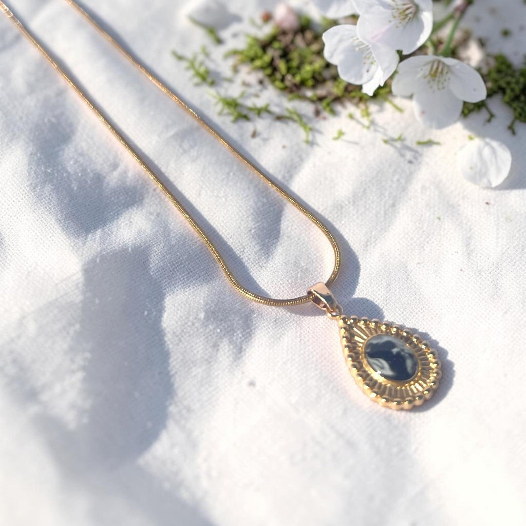 Lise Fiola Creations Sun Ray Drop necklace with dark marbled polymer clay in a 14K gold-plated bezel on a snake chain.