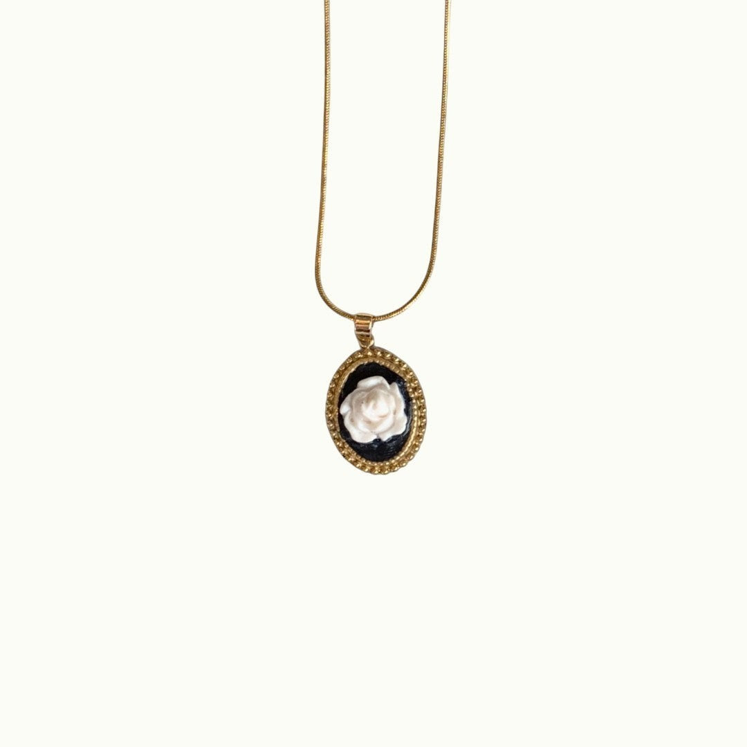 Lise Fiola Creations necklace featuring a handcrafted white polymer clay rose on black in an 18k gold-plated bezel.