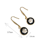 Lise Fiola Creations handmade drop earrings featuring white polymer clay roses on black discs with 18k gold-plated hooks.