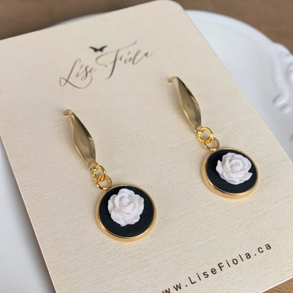 Lise Fiola Creations white rose drop earrings featuring polymer clay flowers on black discs with 18k gold-plated brass